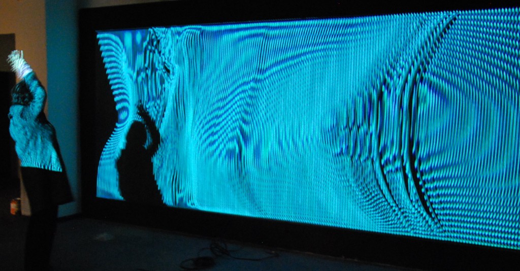 Für das „Fiktive Feld“ hatten Cuppetelli & Mendoza den Ausschnitt einer schwarzen Wandfläche mit elastischen Bändern bespannt und durch eine Projektion beleuchtet, dabei simuliert das projizierte Bild die analoge Struktur des Projektionsgrundes. Foto: Wolfgang Teipel